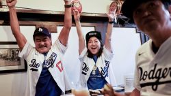 LOS ANGELES, CALIFORNIA - OCTOBER 28: Los Angeles Dodgers fans, tourists from Japan, cheer while watching Game 3 of the World Series against the New York Yankees in the Far Bar in Little Tokyo on October 28, 2024 in Los Angeles, California. The bar and historic Little Tokyo have become a popular destination for Dodgers fans ever since Shohei Ohtani was signed to the team. At Far Bar, every patron will receive a free shot each time Ohtani hits a home run. Little Tokyo is one of just three historic Japantowns remaining in the U.S. (Photo by Mario Tama/Getty Images)