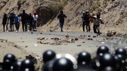 Supporters of former Bolivian President Evo Morales throw rocks at riot police during a protest in Parotani, Cochabamba department, Bolivia, on November 1, 2024. Supporters of Bolivia's ex-president Evo Morales stormed a barracks in central Chapare province and took around 20 soldiers hostage, military sources said Friday, marking a dramatic escalation in their standoff with the state. (Photo by FERNANDO CARTAGENA / AFP) (Photo by FERNANDO CARTAGENA/AFP via Getty Images)