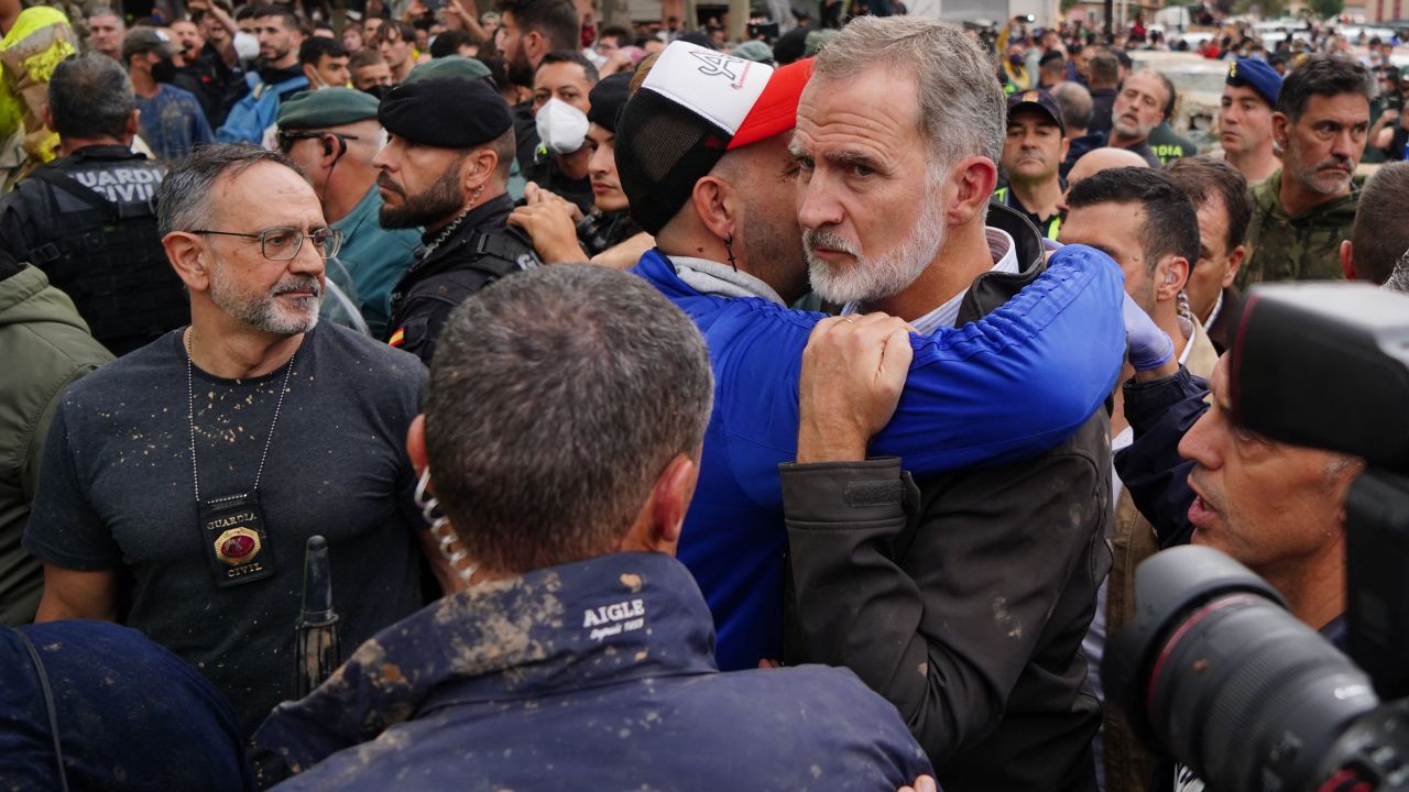 King Felipe VI of Spain (R) is hugged by a man as other angry residents heckled him during his visit to Paiporta, in the region of Valencia, eastern Spain, on November 3, 2024, in the aftermath of devastating deadly floods. A delegation led by Spain's king and prime minister was heckled today as it visited the Valencia region hit by deadly floods, with some screaming "assassins" and others throwing mud, according to AFP journalists on the scene. King Felipe VI and Queen Letizia visited the town of Paiporta, one of the most affected by the floods that have killed more than 200 people, alongside Prime Minister Pedro Sanchez and other officials. (Photo by Manaure Quintero / AFP) (Photo by MANAURE QUINTERO/AFP via Getty Images)