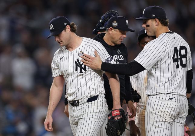 Yankees starting pitcher Gerrit Cole, left, gets a pat on the shoulder from teammate Anthony Rizzo as he leaves the game in the seventh inning Wednesday. All of the five runs scored against Cole were unearned because of New York fielding errors.