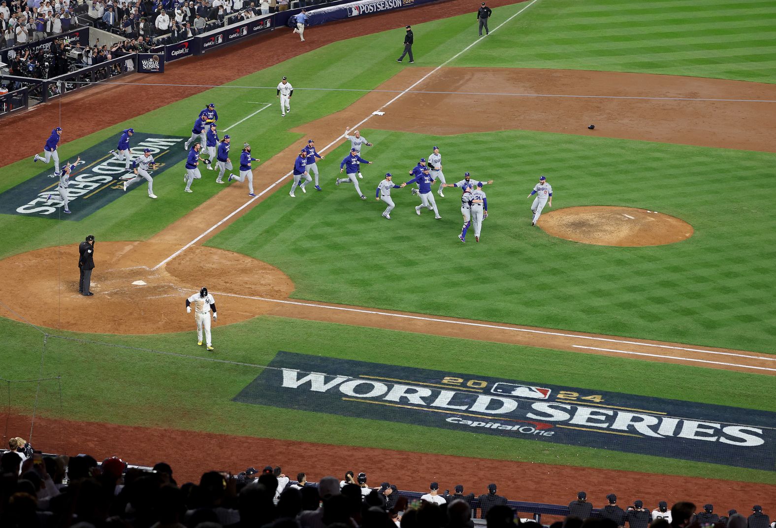 The Dodgers run onto the field after the final pitch Wednesday.