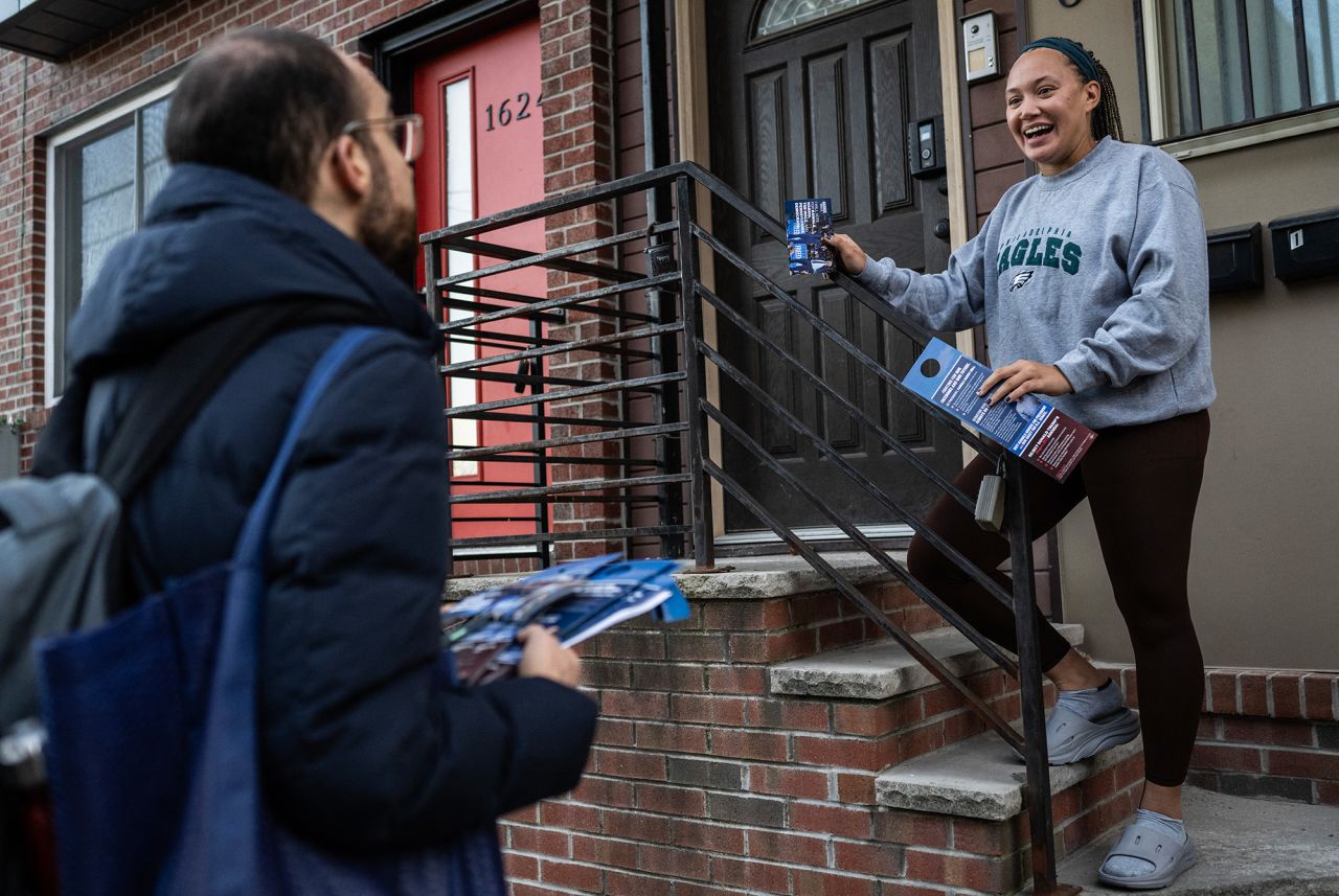 Kamala Harris campaign volunteer Benjamin Reid, left. speaks with Dannah Hayward, as he encourages her to vote during a 'Get Out The Vote' effort two days before election day in Philadelphia, on Sunday.