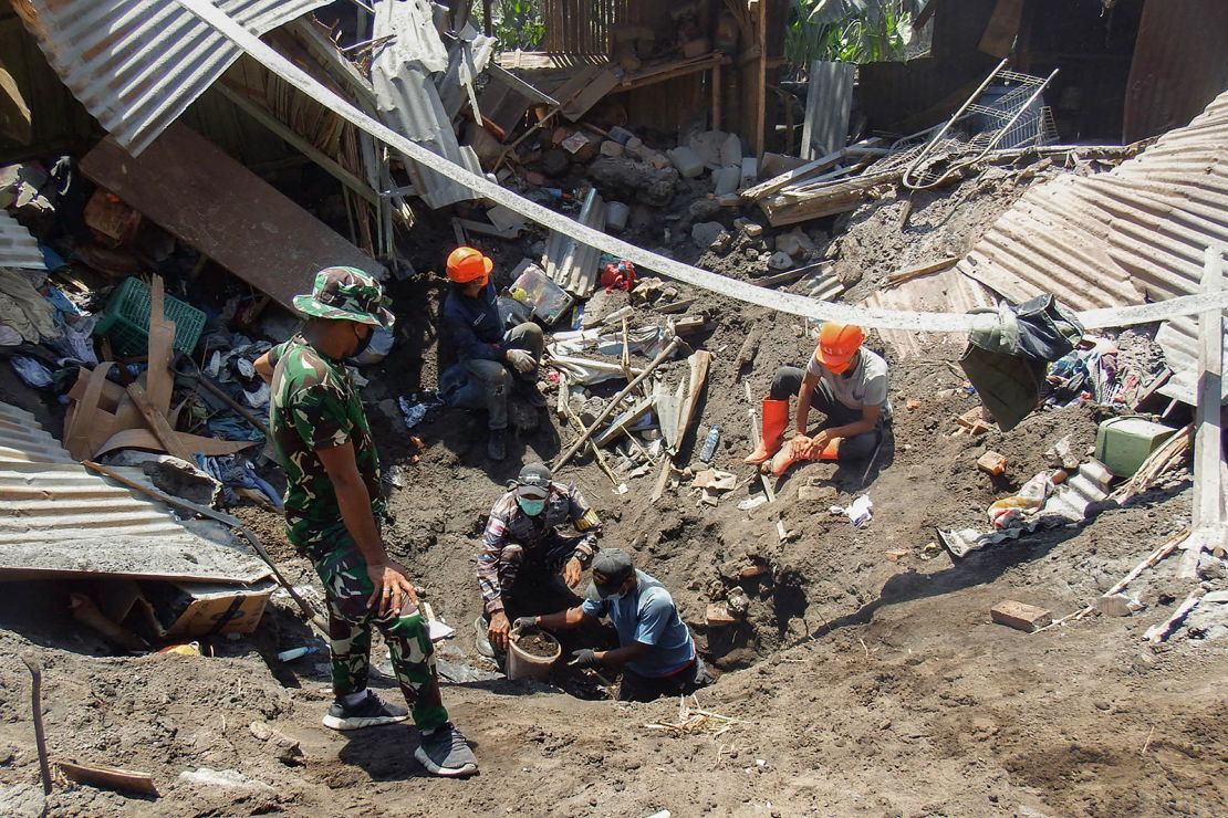 Members of a rescue team search for victims at Klatanlo village.