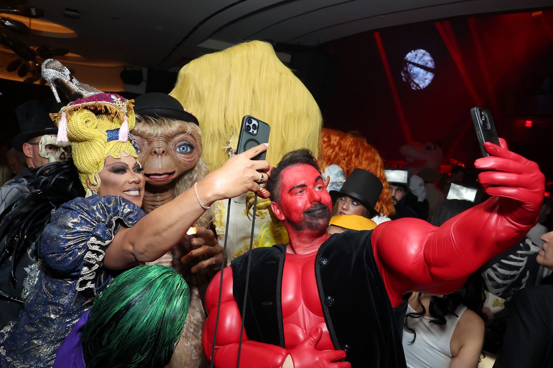 Guests take selfies with Heidi Klum in costume during the party.