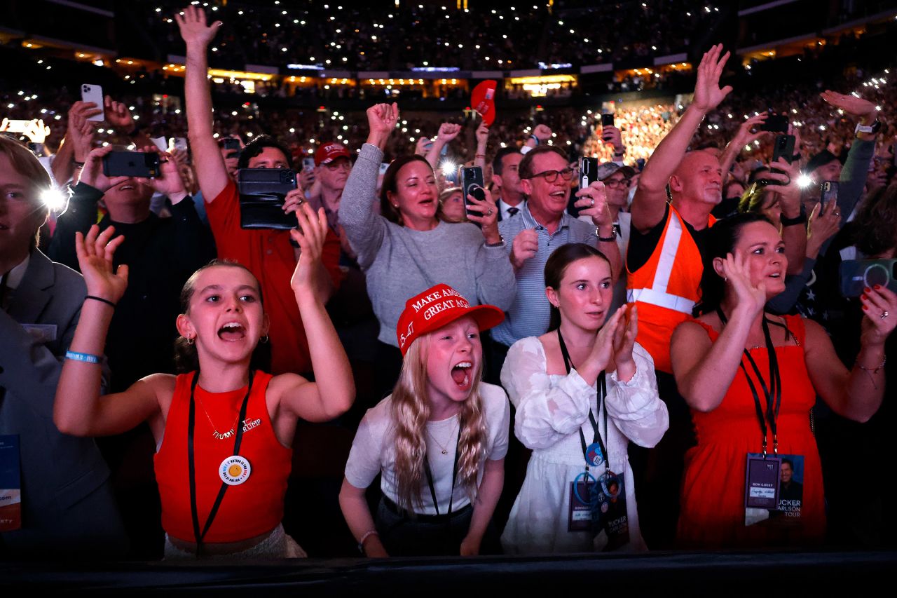 Supporters, young and old, cheer as former President Donald Trump takes the stage for an interview with Tucker Carlson during his Live Tour at the Desert Diamond Arena on October 31 in Phoenix.