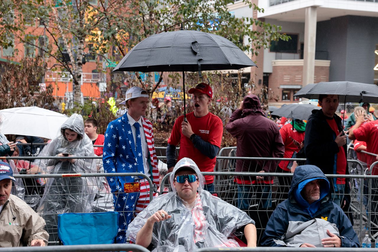 Supporters of Republican presidential candidate Donald Trump wait in the rain to attend Trump's final campaign rally in Grand Rapids, Michigan, on November 4.