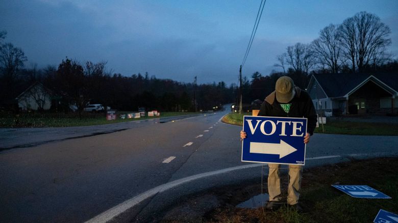 An election worker places a sign outside a polling station in Burnsville, North Carolina, before polls open on November 5, 2024.