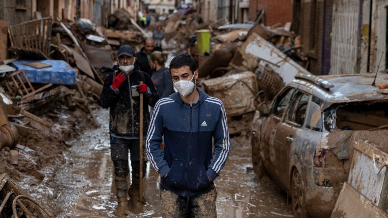 VALENCIA, SPAIN - NOVEMBER 02: People walk along streets full of mud and waste from houses after heavy rain and flooding hit large parts of the country on November 02, 2024 in Paiporta municipality, in Valencia, Spain. By Friday, Spanish authorities confirmed that at least 200 people had died, mostly in the Valencia region, amid the flooding that swept eastern and southern parts of the country starting on Tuesday. The intense rainfall event is known as a "cold drop" or DANA weather system. (Photo by Pablo Blazquez Dominguez/Getty Images)