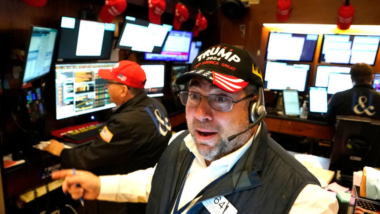 Trader Michael Capolino wears a Trump hat as he works on the floor of the New York Stock Exchange (NYSE) ahead of the opening bell on November 6, 2024, in New York City. Wall Street stocks surged in opening trading on Wall Street Wednesday after US voters sent Donald Trump back to the White House and delivered him a Republican Senate. Major indices were up 1.8 percent or more in the early going as hopes about expected tax cuts and regulatory easing more than offset worries about higher tariffs. (Photo by TIMOTHY A. CLARY / AFP) (Photo by TIMOTHY A. CLARY/AFP via Getty Images)