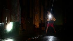 TOPSHOT - A man walks with a torchlight on a darkened street due to a blackout after the pass of hurricane Rafael in Havana, on November 6, 2024. Hurricane Rafael left Cuba on Wednesday night, leaving the island in darkness with widespread power outages and destruction in some villages after hitting as a powerful Category 3 hurricane. (Photo by Yamil LAGE / AFP) (Photo by YAMIL LAGE/AFP via Getty Images)