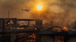 CAMARILLO, CALIFORNIA - NOVEMBER 6: A firefighting helicopter flies near as a home burns from the Mountain Fire on November 6, 2024 in Camarillo, California. Pushed by strong winds, the fire has burned across more than 10,000 acres since it began this morning.  (Photo by David McNew/Getty Images)