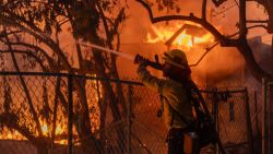 CAMARILLO, CALIFORNIA - NOVEMBER 6: A Los Angeles County firefighter battles flames as a home burns from the Mountain Fire on November 6, 2024 in Camarillo, California. Pushed by strong winds, the fire has burned across more than 10,000 acres since it began this morning.  (Photo by David McNew/Getty Images)