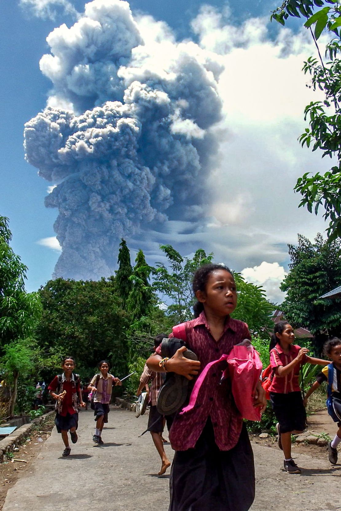 Schoolchildren in the Indonesian village of Lewolaga run during an eruption of Mount Lewotobi Laki-Laki on Thursday, November 7.