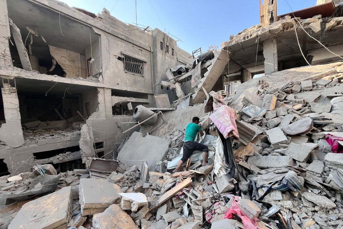 A Palestinian man searches for missing family members, after Israeli bombing flattened a building in Beit Lahiya, in northern Gaza on November 7.