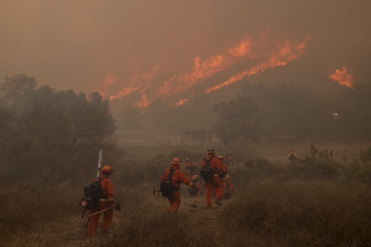 Inmate firefighters with the California Department of Corrections and Rehabilitation walk on a trail while battling the Mountain Fire in Moorpark on Thursday.