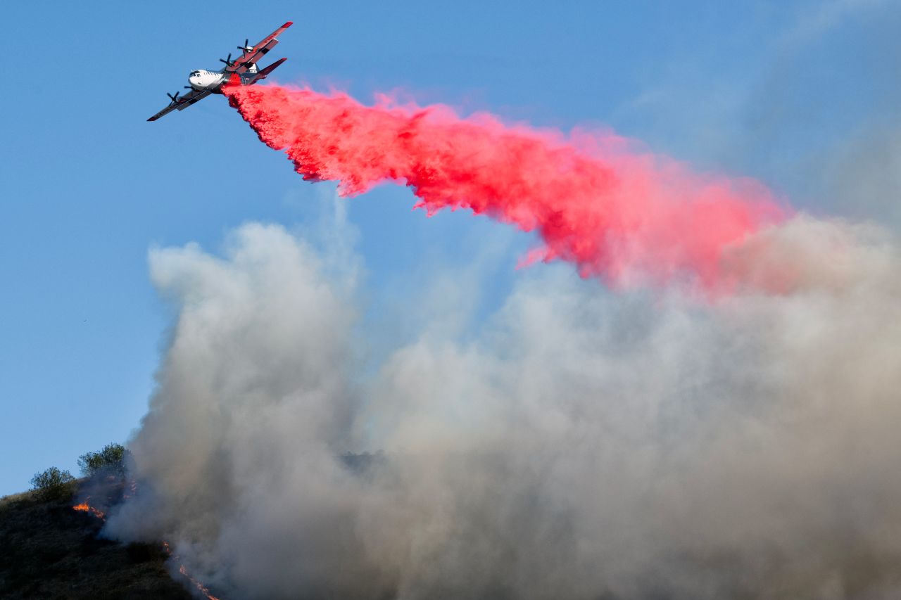 An airplane drops fire retardant on the Mountain Fire near South Mountain Road in Fillmore, California on November 7.