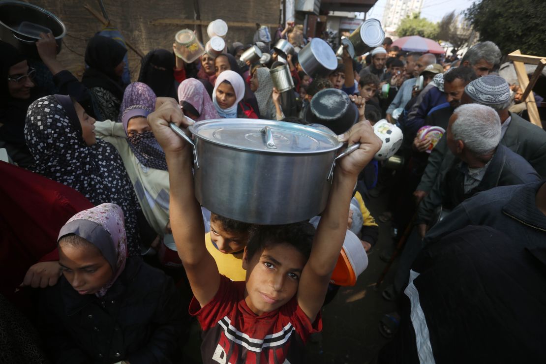 Palestinians wait to receive food distributed by an aid organization in Deir Al Balah, Gaza on November 10.