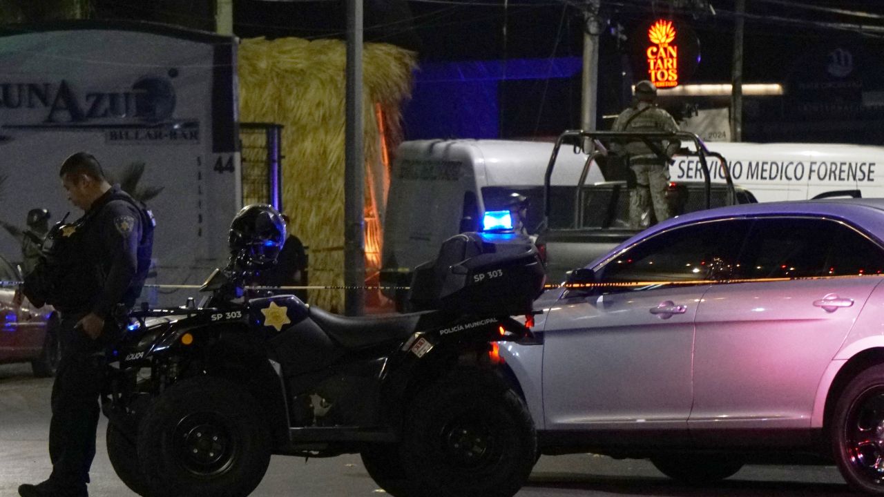 A Mexican Army soldier and a public security agent stand guard outside the Los Cantaritos bar where an armed group broke in on the eve, killing ten people and leaving at least seven more injured, in the city of Queretaro, state of Queretaro, Mexico, on November 10, 2024. (Photo by MARIO ARMAS / AFP) (Photo by MARIO ARMAS/AFP via Getty Images)