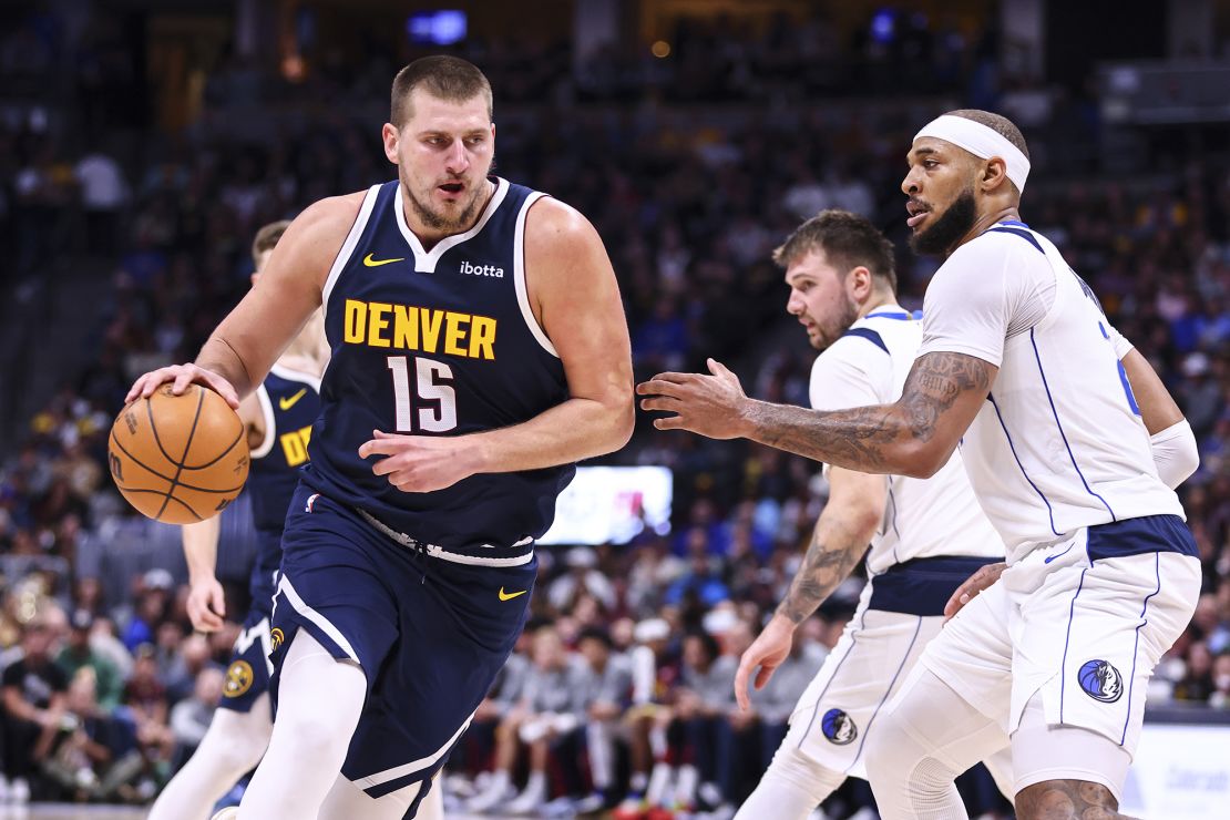 Nikola Jokić dribbles around the Dallas Mavericks' Daniel Gafford in the second half at Ball Arena.