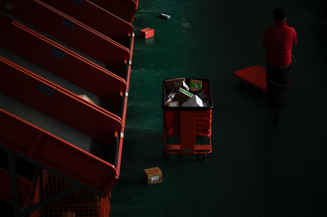 A worker prepares to transfer packages after sorting at a warehouse for an e-commerce company in Beijing on November 11, 2024.