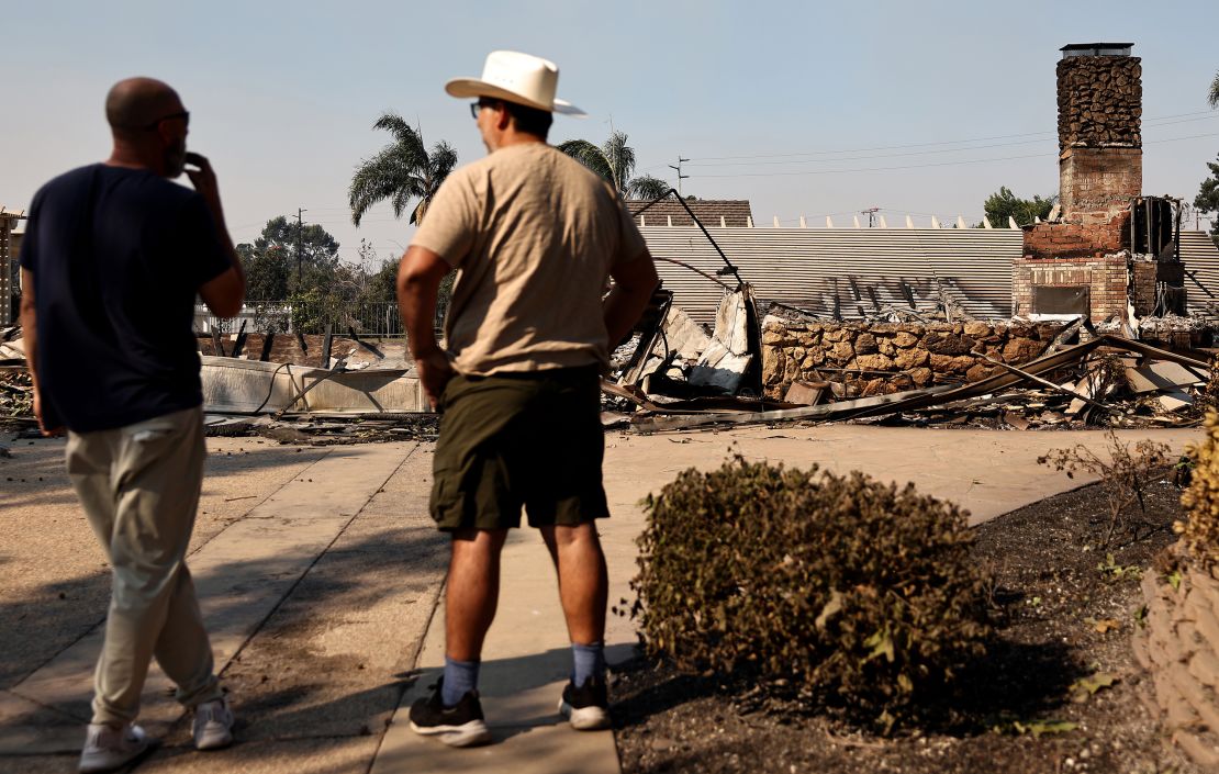 CAMARILLO, CALIFORNIA - NOVEMBER 07: A homeowner (L) surveys his home which was destroyed in the Mountain Fire which continues to burn on November 7, 2024 in Camarillo, California. Fueled by strong winds, the fire has burned across more than 14,000 acres and destroyed numerous homes since it began yesterday. (Photo by Mario Tama/Getty Images)