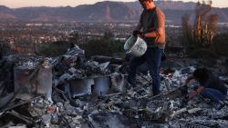 CAMARILLO, CALIFORNIA - NOVEMBER 08: Louie Gonzalez (TOP) and his sister Alicia Jones help their mother search through the rubble of her home which was destroyed in the Mountain Fire on November 8, 2024 in Camarillo, California. Fueled by strong winds, the fire has burned across more than 20,000 acres and destroyed over 100 structures, many of which were homes, since it began November 6.  (Photo by Mario Tama/Getty Images)