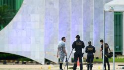 EDITORS NOTE: Graphic content / Brazilian Federal Police forensics stand on November 14, 2024 by the body of man carrying explosives who died in a blast as he attempted to attack Brazil's Supreme Court in Brasilia on November 13, police said, days before the country hosts the G20 summit. Brasilia vice governor said preliminary information suggested it was a "suicide", and came seconds after an explosion in a nearby car that the man was seen getting out of. The man was named as Francisco Wanderley Luiz, a 2020 local council candidate for the Liberal Party of the former president Jair Bolsonaro, according to GloboNews network citing police documents. (Photo by EVARISTO SA / AFP) (Photo by EVARISTO SA/AFP via Getty Images)