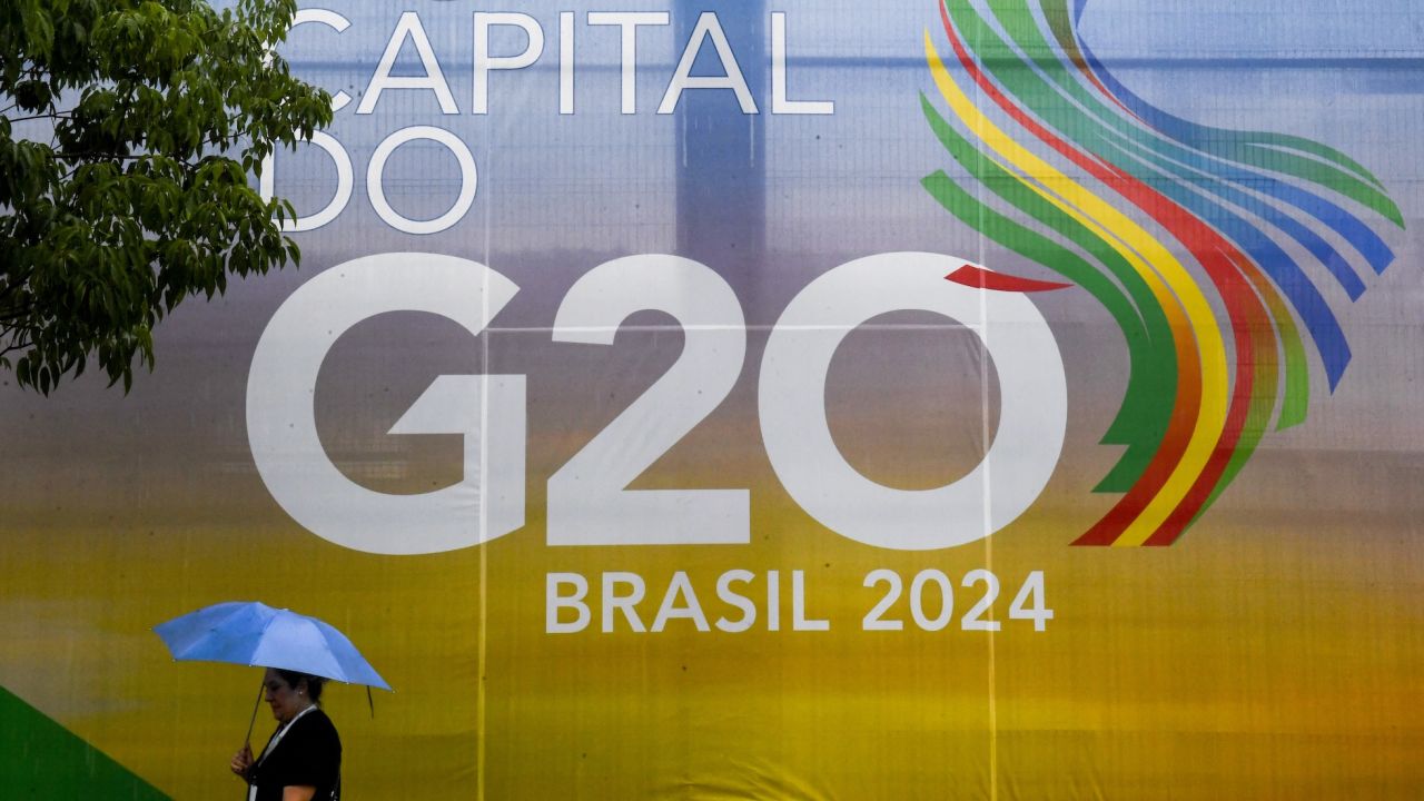 A woman walks carrying an umbrella during the G20 Social Summit in Rio de Janeiro, Brazil, on November 16, 2024. (Photo by Daniel RAMALHO / AFP)