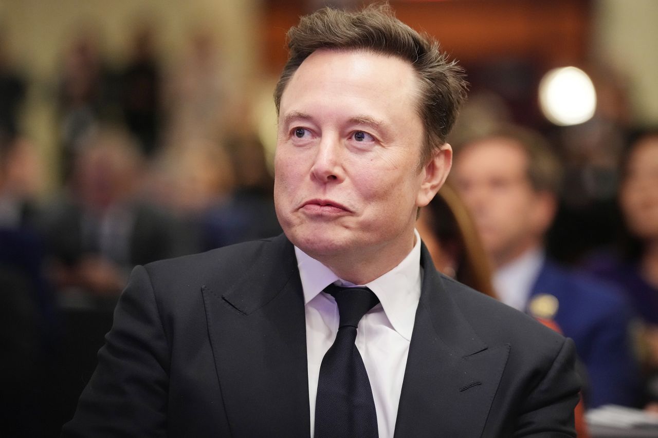 Elon Musk listens as President-elect Donald Trump addresses a House Republicans Conference meeting in Washington, DC, on November 13.