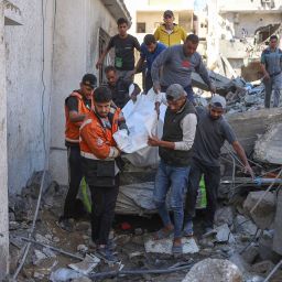 People and rescures carry the covered body of a preson pulled from the rubble of a house destroyed in an Israeli strike on al-Jalaa street in central Gaza City on November 18, 2024, amid the ongoing war between Israel and the Palestinian Hamas militant group. (Photo by Omar AL-QATTAA / AFP) (Photo by OMAR AL-QATTAA/AFP via Getty Images)