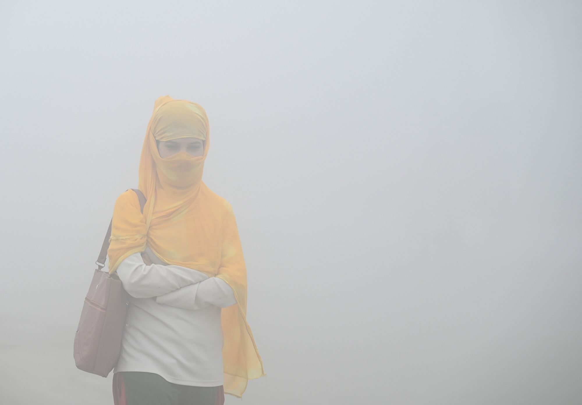 Commuters step out in a foggy winter morning amid rising air pollution on November 19, 2024 in Greater Noida, on the outskirts of Delhi.