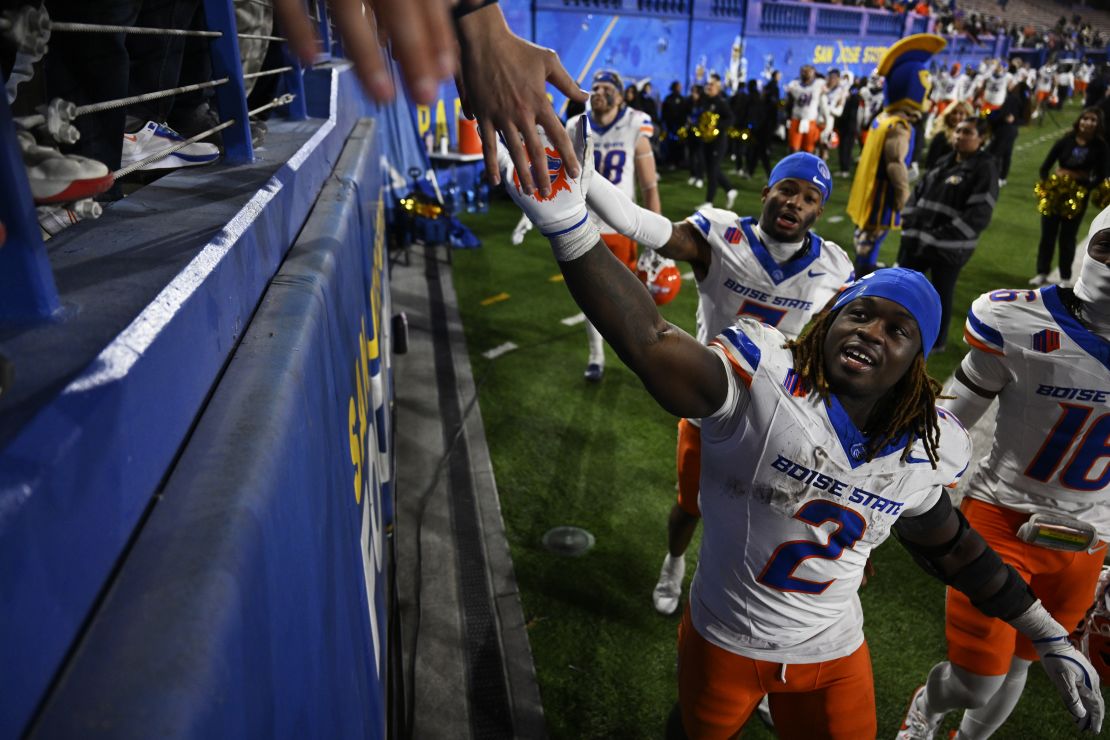 Ashton Jeanty high fives fans after Boise State's win.