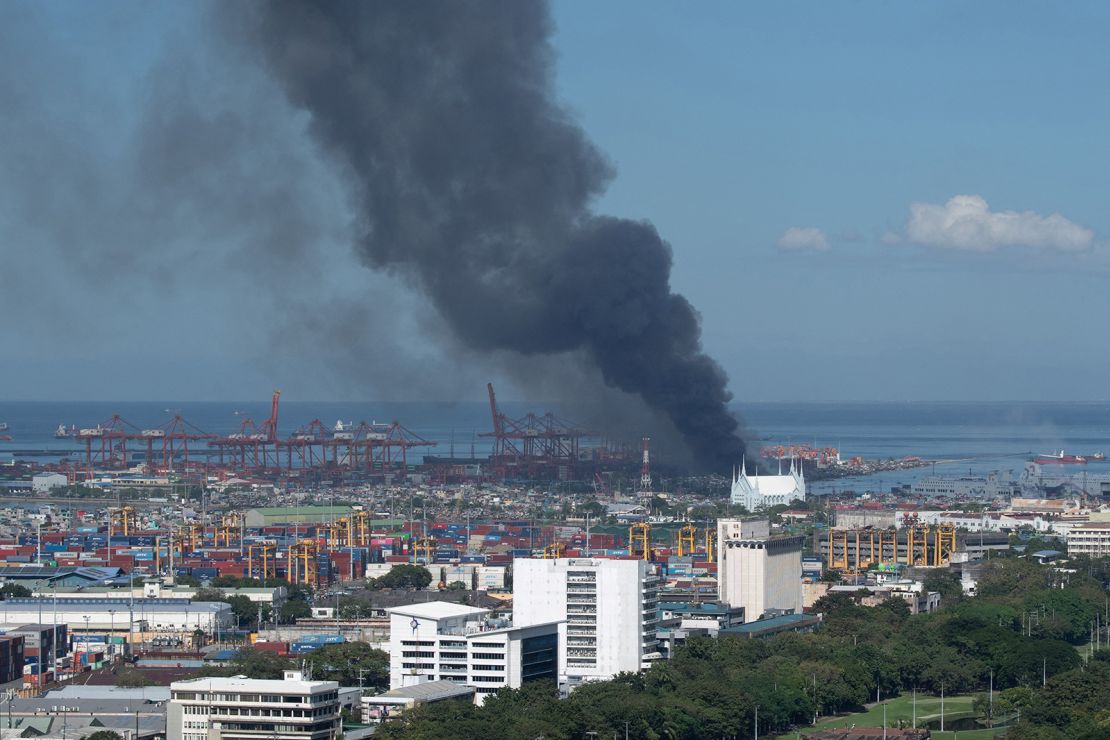 Black smoke rises during a fire in the Isla Puting Bato residential area in Manila on November 24, 2024.