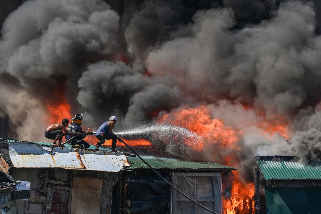 Residents and firefighters put out a fire at Tondo in Manila on November 24, 2024.