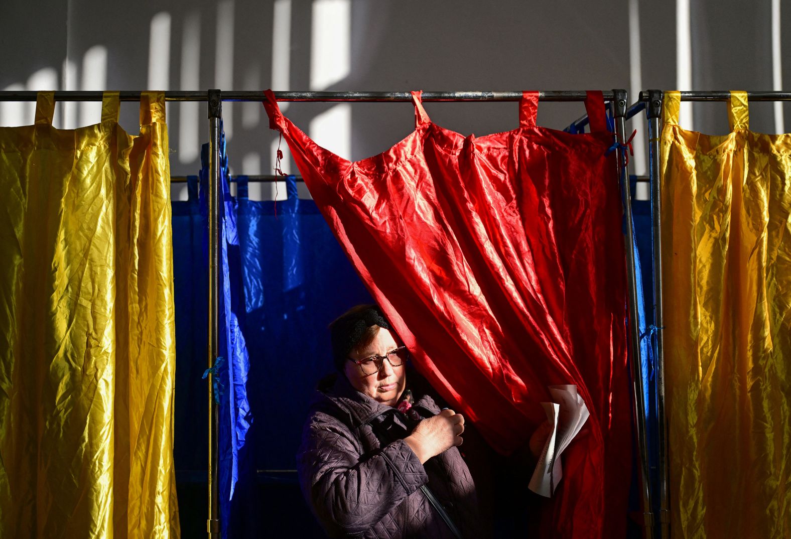 TOPSHOT - A woman leaves the polling booth prior to vote for the presidential elections at a polling station in Bucharest on November 24, 2024. Romanians vote on November 24, 2024 in the first round of the presidential elections. The Social Democratic Prime Minister (PSD), Marcel Ciolacu, 56, remains the favorite with some 25% of voting intentions. (Photo by Daniel MIHAILESCU / AFP) (Photo by DANIEL MIHAILESCU/AFP via Getty Images)