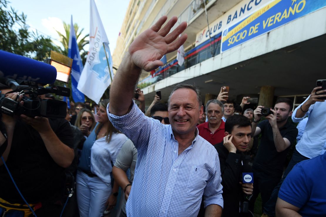 Uruguay's presidential candidate for the Republican Coalition, Alvaro Delgado, waves to supporters outside a polling station after voting during the presidential runoff election in Montevideo on November 24.