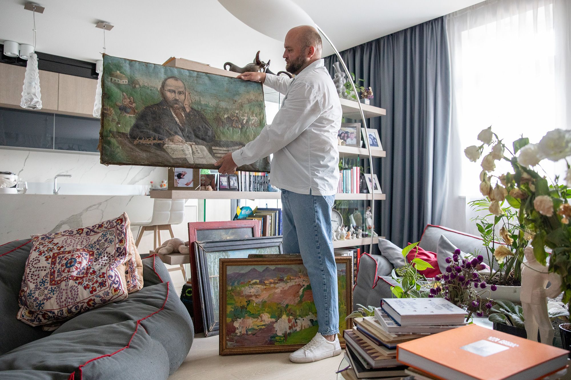 Ukrainian historian Leonid Marushchak has rescued around 2 million artifacts from frontline areas, sometimes under heavy fighting. Here, he holds a painting of Ukrainian poet, Taras Shevchenko.