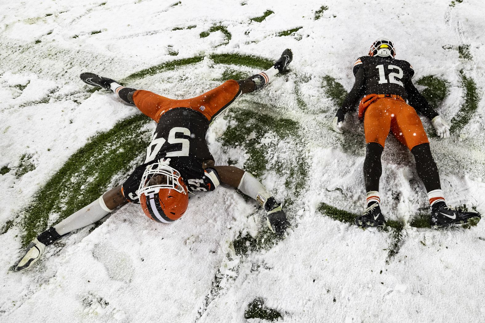 CLEVELAND, OHIO - NOVEMBER 21: Ogbo Okoronkwo #54 of the Cleveland Browns and Rodney McLeod Jr. #12 make snow angels after the game against the Pittsburgh Steelers at Huntington Bank Field on November 21, 2024 in Cleveland, Ohio. The Browns beat the Steelers 24-19. (Photo by Lauren Leigh Bacho/Getty Images)