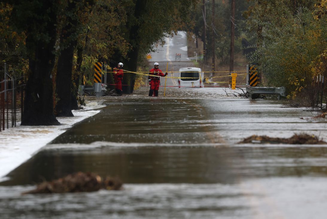 Firefighters block off a flooded road on November 22, 2024, in Windsor, California, after a powerful atmospheric river brought heavy rain and wind to the San Francisco Bay Area.