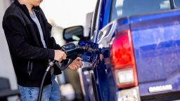 A man stops to fill up his car at a gas station in Washington, DC.