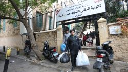 Displaced people carry their belongings as they leave a school turned shelter in Beirut on November 27, 2024, as people return to their homes after a ceasefire between Israel and Hezbollah took effect. A ceasefire between Israel and Hezbollah in Lebanon took hold on after more than a year of fighting that has killed thousands. (Photo by IBRAHIM AMRO / AFP) (Photo by IBRAHIM AMRO/AFP via Getty Images)