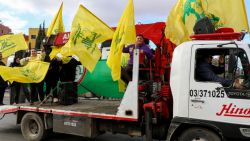 People wave the flag of the Lebanese movement Hezbollah as residents return to the city of Baalbek on November 27, 2024, after a ceasefire between Hezbollah and Israel took effect. A ceasefire between Israel and Hezbollah in Lebanon took hold on November 27 after more than a year of fighting that has killed thousands. (Photo by Nidal SOLH / AFP) (Photo by NIDAL SOLH/AFP via Getty Images)