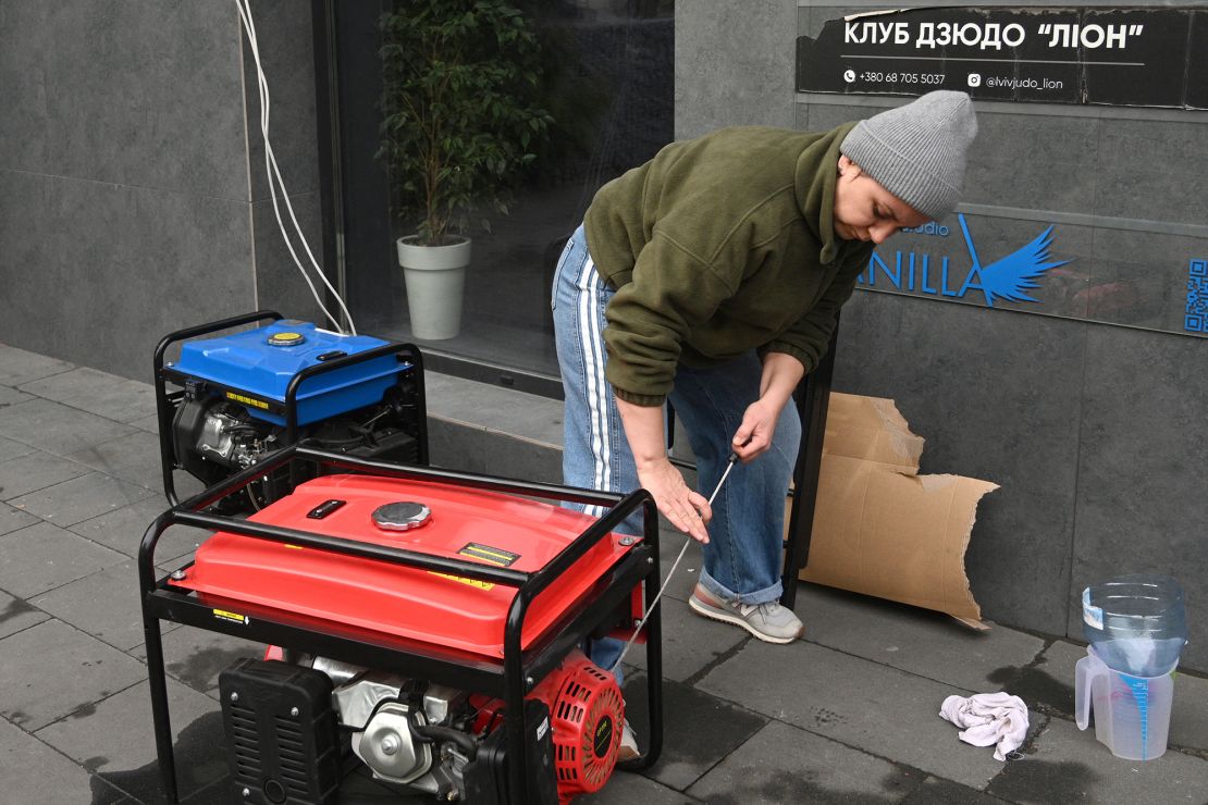 A local resident starts a generator during a power outage in Lviv following Russia's aerial attacks.