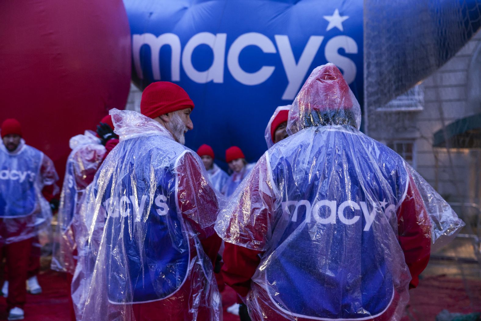 People gather as rain falls Thursday ahead of the parade in New York.