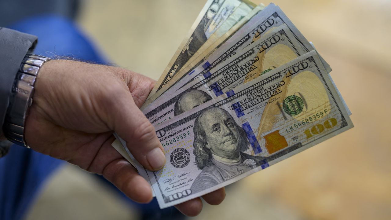 A teller shows US dollar bills at an exchange office at the Grand Bazaar in Istanbul on November 28, 2024. In recent weeks, the Turkish market has been increasingly unsettled by growing concerns over the circulation of counterfeit $50 and $100 bills. (Photo by Yasin AKGUL / AFP) (Photo by YASIN AKGUL/AFP via Getty Images)