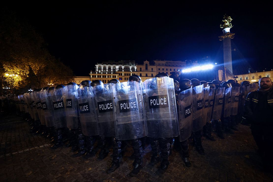 Police officers stand in position as demonstrators gather in front of Georgia's parliament in Tbilisi on November 28, 2024.