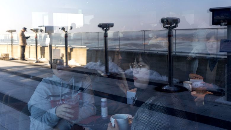 Customers inside a Starbucks Coffee Korea Co. store, with views of North Korea's Gaepung County, at the Aegibong Peace Ecopark in Gimpo, South Korea, on Friday, Nov. 29, 2024. The 30-seater cafe opened Friday, offering its customers in the south a peek into the worlds most reclusive country while sipping a favorite brew.