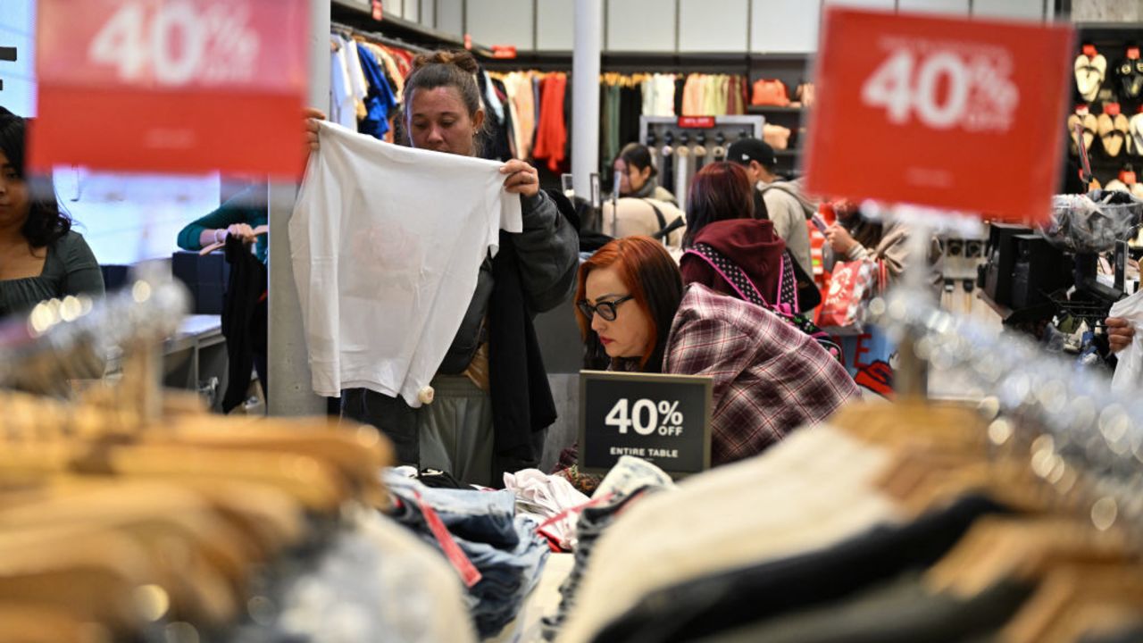 People shop at a Guess store for early Black Friday deals on Thanksgiving Day, November 28, 2024, at the Citadel Outlets shopping center in Los Angeles. Stores at the Citadel Outlet shopping center opened at 8pm on Thursday November 28 and will remain open all night for their "Black Friday Early Access Event." (Photo by Robyn Beck / AFP) (Photo by ROBYN BECK/AFP via Getty Images)