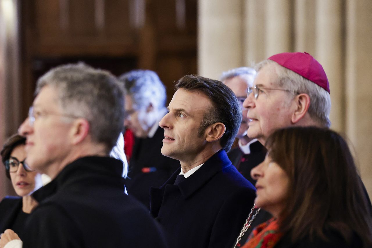 French President Emmanuel Macron, Paris' archbishop Laurent Ulrich and Paris' mayor Anne Hidalgo look up during a visit to Notre Dame Paris cathedral in Paris on November 29.