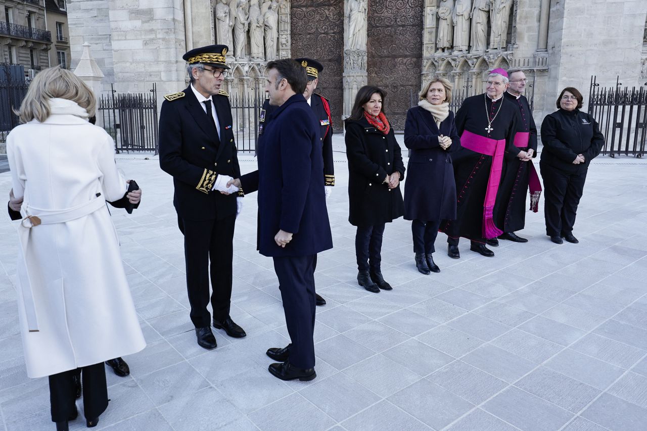 French President Emmanuel Macron shakes hands with Ile-de-France prefect Marc Guillaume next to Paris' prefect Laurent Nunez, Paris' mayor Anne Hiladgo, Ile-de-France's President Valerie Pecresse and Paris' archbishop Laurent Ulrich as he arrives to visit Notre Dame cathedral in Paris, on November 29.